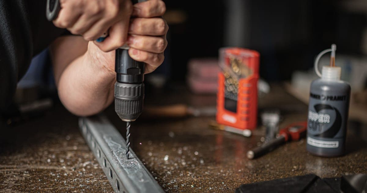 Hammer drill boring a hole in a concrete patio slab for an anchor bolt