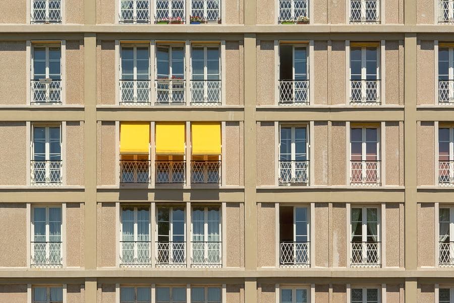 Building facade with yellow fabric sunshades extended over a row of windows
