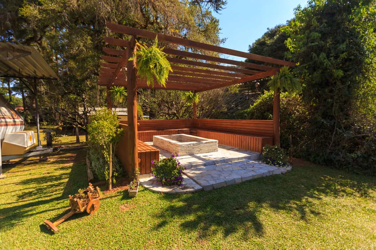 Two different backyard shade structures seen across a garden