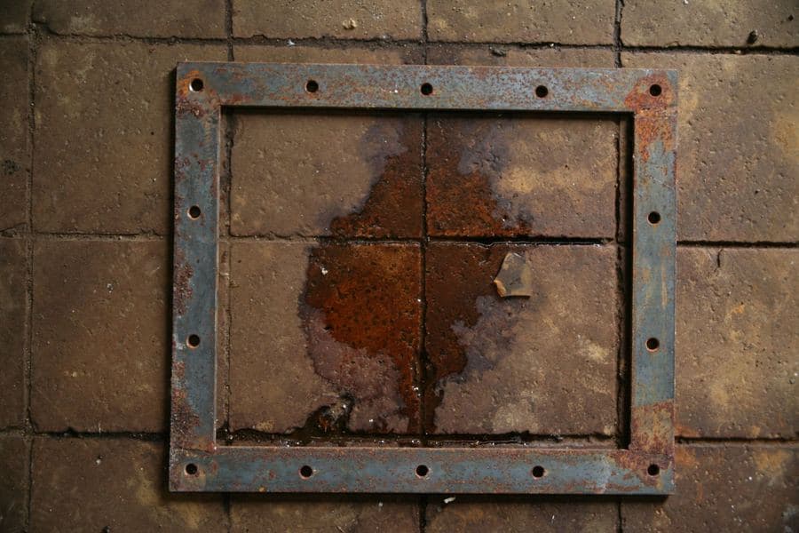 Close-up of a weathered powder-coated metal frame section showing its finish and fixings