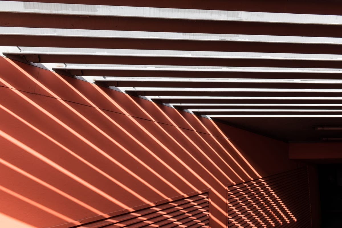 Sunlight filtering through a woven shade fabric casting a dappled pattern