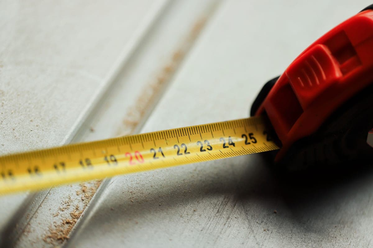 Tape measure laid across a paved patio in daylight