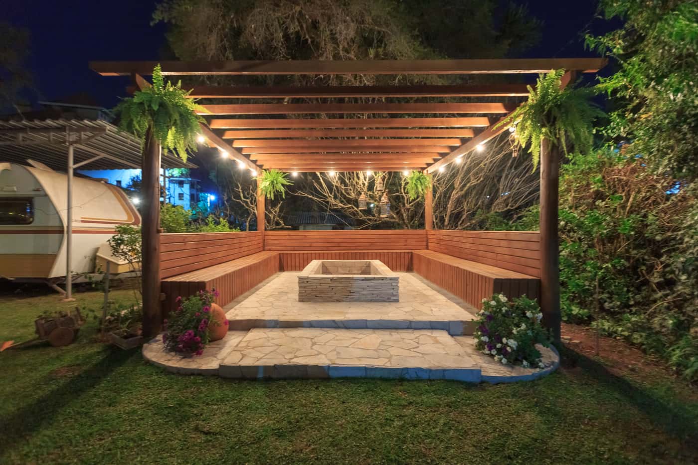 Aluminum louvered pergola with open roof slats over a paved backyard patio in daylight