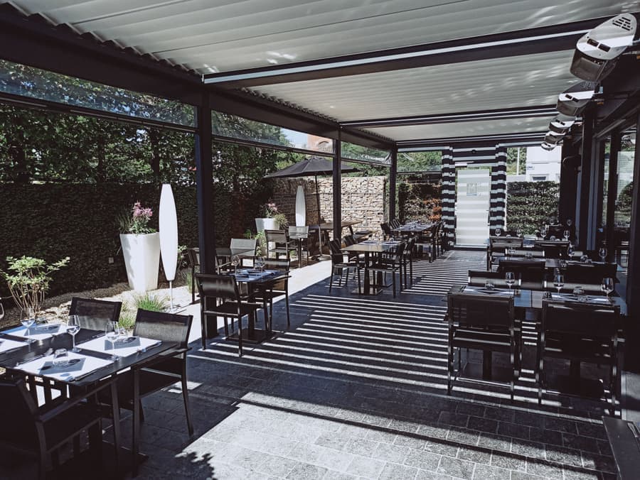 Aluminum structure with a translucent polycarbonate roof panel over a wooden deck